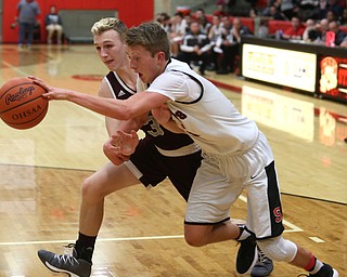 Struthers' Carson Ryan (5) dribbles towards the basket as Boardman guard Holden Lipke (3) attempts to steal the ball in the second quarter of an AAC high school basketball game, Tuesday, Jan. 16, 2018, in Struthers. Boardman won 71-48...(Nikos Frazier | The Vindicator)