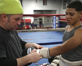 Brayan Colon waits as trainer Vinny O'Neil tapes up his gloves, Tuesday, Jan. 16, 2018, at the Southside Boxing Gym in Youngstown...(Nikos Frazier | The Vindicator)