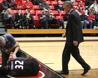 UIC head coach Steve McClain walks over to check on UIC center Clint Robinson (32) after falling while attempting a layup in the second half of a NCAA college basketball game against Youngstown State, Thursday, Jan. 18, 2018, in Youngstown. UIC won 92-78...(Nikos Frazier | The Vindicator)