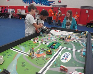 Neighbors | Zack Shively.Judges at the FIRST LEGO League competition scored teams based on core values, their project and their robot design. Pictured, students worked on their robot design where they had to accomplish a series of tasks on the board shown.