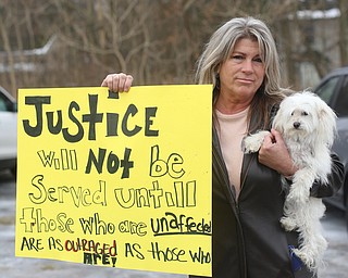 Karen Carusone of Girard poses for a photo with her dog Coco Chanel, as close to 200 community members attend a protest rally demanding the release of Al Adi, Sunday, Jan. 21, 2018, outside the Northeast Ohio Correctional Facility in Youngstown...(Nikos Frazier | The Vindicator)