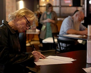 Carol Morris of Youngstown write a letter to Rebecca Adducci, Director of the Detroit ICE Field Office, Monday, Jan. 22, 2018, at Downtown Circle in Youngstown...(Nikos Frazier | The Vindicator)