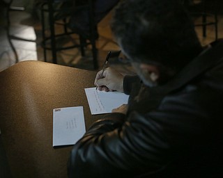 Omar Mobydeen of Cleveland writes a letter to his friend Al Adi, Monday, Jan. 22, 2018, at Downtown Circle in Youngstown...(Nikos Frazier | The Vindicator)