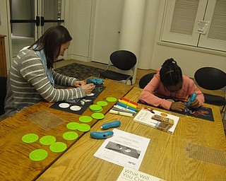 Neighbors | Zack Shively.The 3D pen worked like a 3D printer. They placed plastic material in one end of the pen and the the other end sent out a stringy plastic that one can design with. Pictured from left, Alison Graf and Kennedy work on their 3D art.
