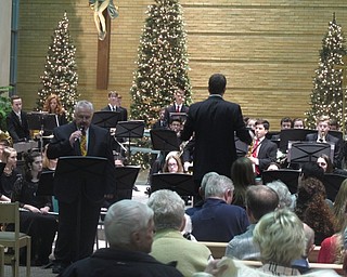 Neighbors | Zack Shively.Poland Seminary High School had their winter concert featuring their concert band and choirs at Holy Family Church in poland on Dec. 16. Pictured, Jim Penney read an article while the band, directed by Jeff Hvizdos, played behind him during the song "Yes Virginia, There is a Santa Claus."