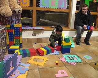 Neighbors | Zack Shively.The Davis Center had an area set up for children to play with building blocks as a part of their toyland theme. Pictured, Dan Johnson watches his son Flynn play with the blocks.