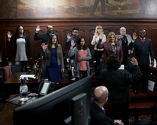 Nine men and women raise their hands as they take the oath of citizenship during a naturalization ceremony, Thursday, Jan. 24, 2018, at the Mahoning County Courthouse in Youngstown...(Nikos Frazier | The Vindicator)