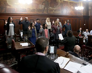 Nine men and women raise their hands as they take the oath of citizenship during a naturalization ceremony, Thursday, Jan. 24, 2018, at the Mahoning County Courthouse in Youngstown...(Nikos Frazier | The Vindicator)
