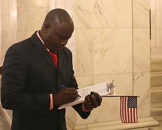 Joseph Tetteh Odonkor registers to vote after being sworn in as a US citizen during a naturalization ceremony, Thursday, Jan. 24, 2018, at the Mahoning County Courthouse in Youngstown...(Nikos Frazier | The Vindicator)