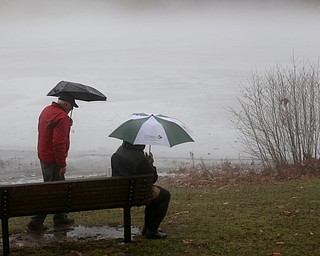 Bob and Judith Stanger of Boardman sit on a bench at Glacier Lake looking at the fog layer created by warm rain interacting with the ice layer on the surface of the lake, Thursday, Jan. 11, 2018, in Mill Creek Park. ..(Nikos Frazier | The Vindicator)