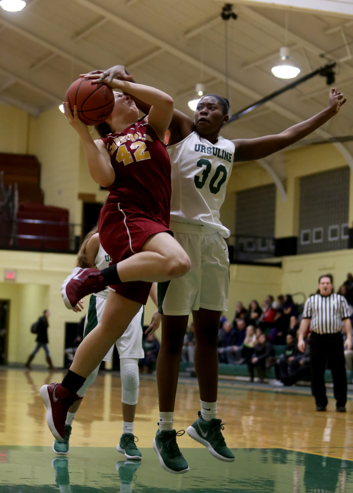 Ursuline's Anyah Curd (30) reaches around to block Cardinal Mooney Conchetta Rinaldi (42)s layup in the first quarter of an OSHAA basketball game, Thursday, Feb. 1, 2018, in Youngstown. Ursuline won 76-54...(Nikos Frazier | The Vindicator)