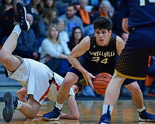 NEW MIDDLETOWN, OHIO - FEBRUARY 2, 2018: Lowellville's Joe Ballone protects the ball while looking to pass after Springfield's Drew Clark dove in an attempt to knock the ball away during the first half of their game on Friday night at Springfield High School. DAVID DERMER | THE VINDICATOR