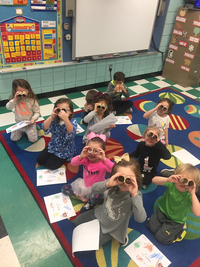 Above, students of Barbara Conti, a Preschool Enrichment class teacher at Ursuline Preschool and Kindergarten, are studying bears and their habitats. The students made maps and “binoculars” to help them search for the cave and bears.