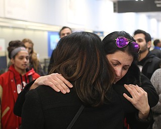 Fidaa Mushleh(back) hugs Amal Saleh goodbye before departing for her flight to reunite with her husband, Al Adi in Amman, Jordan, Wednesday, Feb. 7, 2018, at Cleveland Hopkins International Airport in Cleveland. Adi was deported to Jordan last week after 13 days in ICE detainment...(Nikos Frazier | The Vindicator)