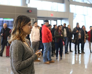 Lina Adi watches as her mother, Fidaa Musleh, slowly makes her way through a TSA Security Checkpoint to reunite with her husband Al Adi in Amman, Jordan, Wednesday, Feb. 7, 2018, at Cleveland Hopkins International Airport in Cleveland. ..(Nikos Frazier | The Vindicator)