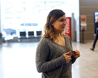 Lina Adi watches as her mother, Fidaa Musleh, slowly makes her way through a TSA Security Checkpoint to reunite with her husband Al Adi in Amman, Jordan, Wednesday, Feb. 7, 2018, at Cleveland Hopkins International Airport in Cleveland. ..(Nikos Frazier | The Vindicator)