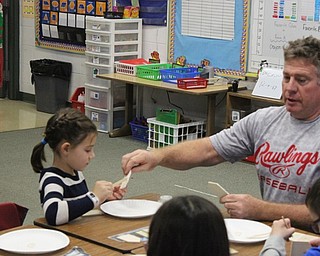 Neighbors | Abby Slanker.Canfield School Board member Barry Tancer helped a C.H. Campbell Elementary School second-grade student construct a mini wooden gingerbread house ornament on Dec. 18.