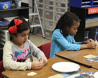 Neighbors | Abby Slanker.Two C.H. Campbell Elementary School second-grade students worked hard to build mini wooden gingerbread house ornaments on Dec. 18.