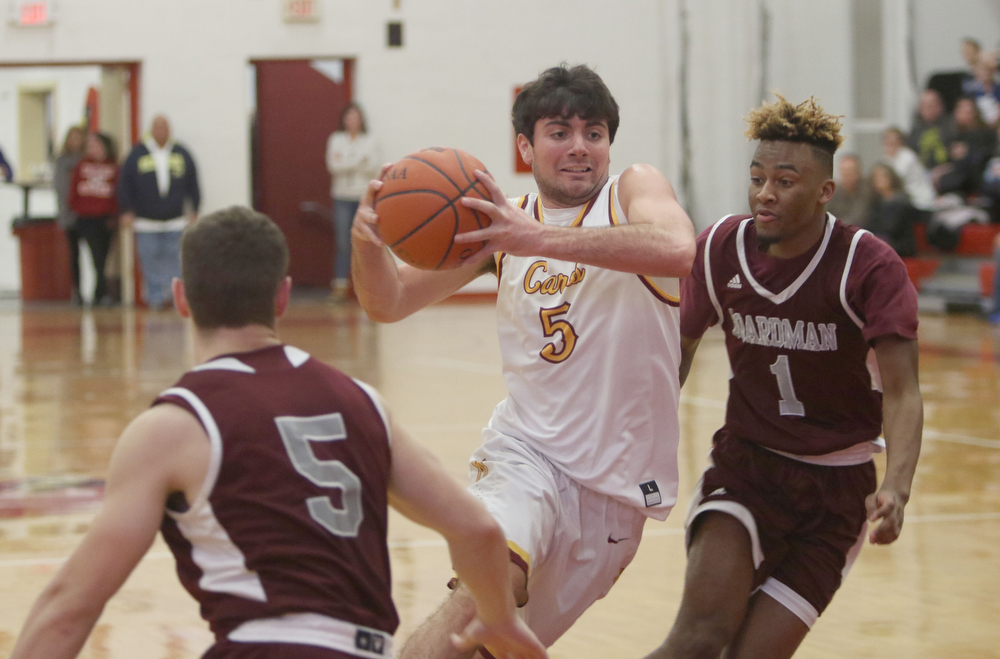             ROBERT  K. YOSAY | THE VINDICATOR..Boardmn at Cardinal Mooney ..#5 Mooney Pete Haas   drives between Boadmna #5 Mike Melewski and #1  Jajuante  Young  during first quarter action