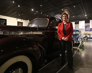 Executive Director Mary Ann Porinchak poses for a photo next to a 1940 One-Ten Touring Sedan Model 1800, Wednesday, Jan. 24, 2018, at the Packard Museum in Warren...(Nikos Frazier | The Vindicator)