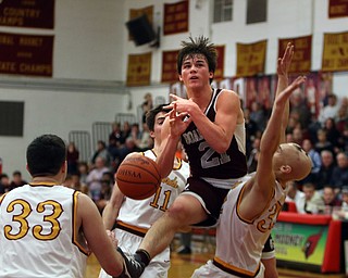             ROBERT  K. YOSAY | THE VINDICATOR..Boardmn at Cardinal Mooney ..Boardmans Cam Kreps gets fouled as he losses the ball during first quarter action #11 Mooney Anthony Fire and#32 Johnie Mikos number 33 Johnny Murphy