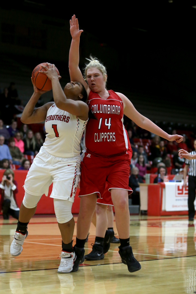 Struthers' Khaylah Brown (1) pauses under Columbiana's Marisa McDonough (14)'s arm before attempting a layup in the first quarter of an OHSAA high school basketball game, Monday, Feb. 12, 2018, in Struthers. Struthers won 61-52...(Nikos Frazier | The Vindicator)