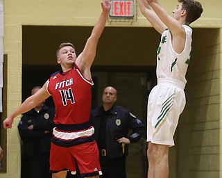 Ursuline forward Ethan Courtney (32) goes up for three as Austintown Fitch forward Kole Klasic (14) attempts to block his shot in the first quarter of an OHSAA high school basketball game, Tuesday, Feb. 13, 2018, in Youngstown. Ursuline won 63-58...(Nikos Frazier | The Vindicator)