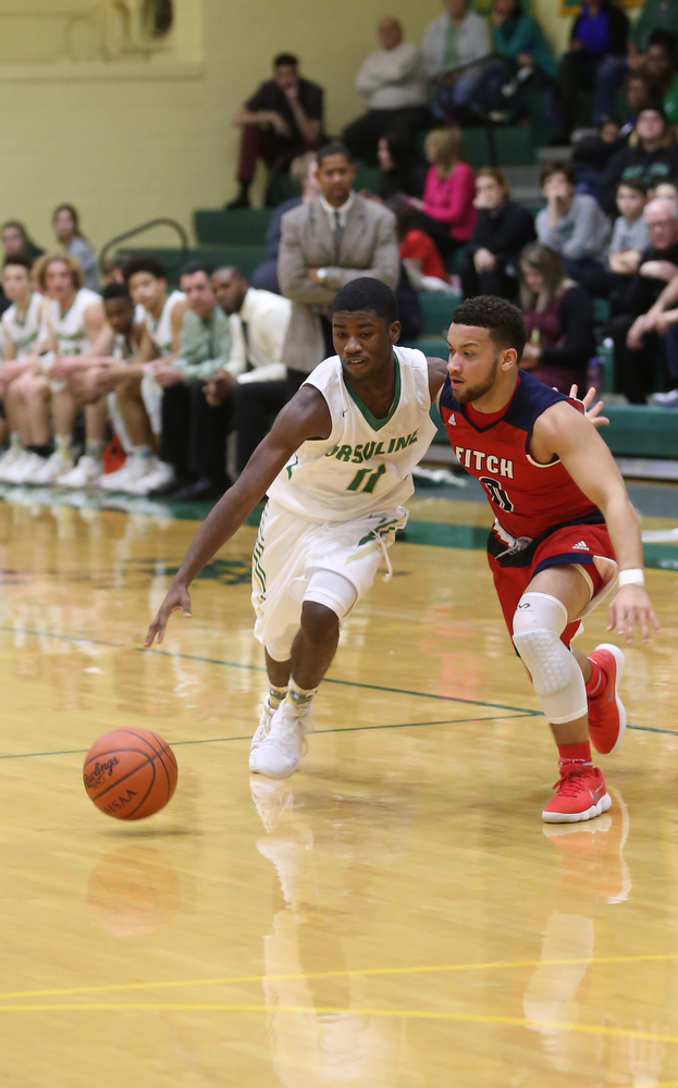 Ursuline guard Nicolas Venzeio (11) drives past Austintown Fitch forward Randy Smith (0) in the second quarter of an OHSAA high school basketball game, Tuesday, Feb. 13, 2018, in Youngstown. Ursuline won 63-58...(Nikos Frazier | The Vindicator)