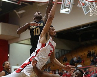 Youngstown State forward Devin Haygood (2) goes up for a layup over Oakland forward Jalen Hayes (4) as Oakland forward Isaiah Brock (10) attempts to block his shot from behind in the first half of an NCAA Horizon League college basketball game, Wednesday, Feb. 14, 2018, in Youngstown. YSU won 75-73...(Nikos Frazier | The Vindicator)