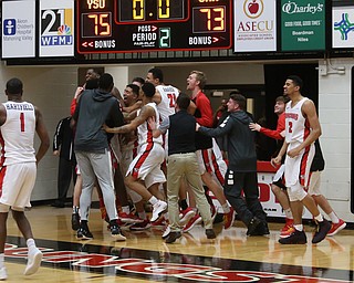 The YSU bench swarms Youngstown State guard Garrett Covington (32) after his buzzer beater basket in the second half of an NCAA Horizon League college basketball game, Wednesday, Feb. 14, 2018, in Youngstown. YSU won 75-73...(Nikos Frazier | The Vindicator)