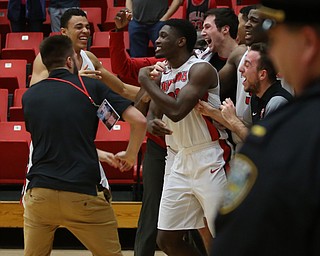 The YSU bench swarms Youngstown State guard Garrett Covington (32) after his buzzer beater basket in the second half of an NCAA Horizon League college basketball game, Wednesday, Feb. 14, 2018, in Youngstown. YSU won 75-73...(Nikos Frazier | The Vindicator)