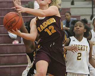 William D. Lewis The Vindicator   South Range's Bree Kohler(12) shoots over Liberty's Zion Jones(2) during 2-14-18 action at Liberty.