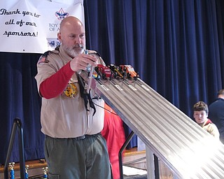 Neighbors | Zack Shively.The Scouts competed in 90 races throughout the day at the Pinewood Derby. Each car raced in each lane at least once during the day. Pictured, Cub Master Don Wittman placed the four cars in their lanes for a race.