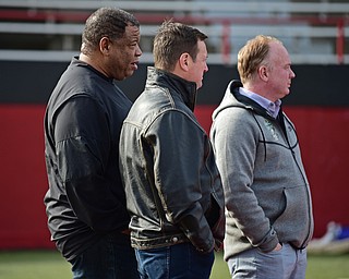 YOUNGSTOWN, OHIO - FEBRUARY 18, 2018: Kentucky head coach Mark Stoops, right, Kentucky assistant coach Vince Marrow, left, and former Oklahoma head coach Bob Stoops stand on the sideline during the Youngstown State practice on Sunday afternoon at Stambaugh Stadium. DAVID DERMER | THE VINDICATOR