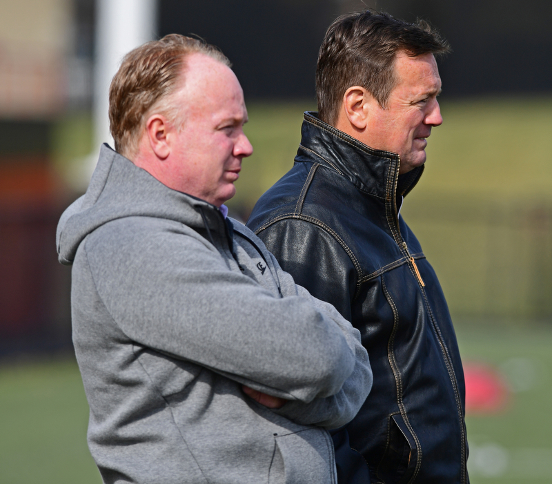 YOUNGSTOWN, OHIO - FEBRUARY 18, 2018: Kentucky head coach Mark Stoops and former Oklahoma head coach Bob Stoops stand on the sideline during the Youngstown State practice on Sunday afternoon at Stambaugh Stadium. DAVID DERMER | THE VINDICATOR