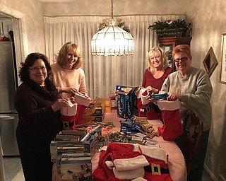 General Federation of Women’s Clubs Ohio Warren Junior Women’s League public issues committee packaged more than 75 holiday stockings for the troops. Stockings were filled with hot chocolate, cookies, crackers, popcorn, playing cards, holiday ornaments and holiday wishes. Committee members filling stockings, above, from left, are Sandra Saluga; Sharon Drummond; Becky Andres, co-chairwoman; and Pam Vines.