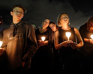 People participate in Monday's candlelight vigil in memory of the 17 students and faculty who were killed in Wednesday's mass shooting at Marjory Stoneman Douglas High School in Parkland, Fla.