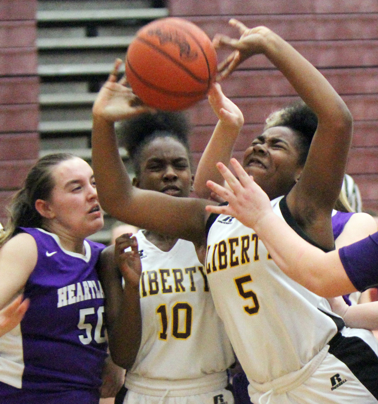 William D Lewis The Vindicator  Liberty's Delia Watson(5) shoots around Heartland's Megan Johnson (50) during 2-21-18 action at Liberty. Liberty's Sierra Williams(10) is at center.