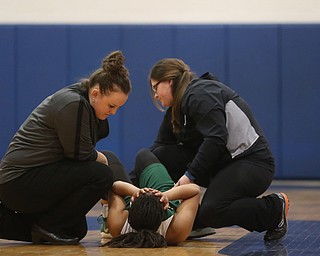 Ursuline's Dayshonette Harris (1) is examined by a trainer after an injury in the fourth quarter of an Division II sectional final high school basketball game, Thursday, Feb. 22, 2018, in Poland. Poland won 50-49...(Nikos Frazier | The Vindicator)