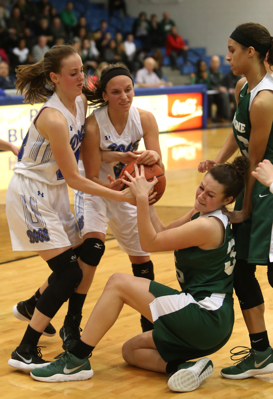 Poland guard Sarah Bury (2)(center) and Poland forward Maggie Sebest (13) hold onto the ball as Ursuline's Lindsay Bell (35) falls to the grounf in the fourth quarter of an Division II sectional final high school basketball game, Thursday, Feb. 22, 2018, in Poland. Poland won 50-49...(Nikos Frazier | The Vindicator)