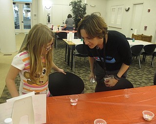 Neighbors | Zack Shively.The Austintown library had an "I love STEAM" program on Feb. 12. Pictured, librarian Nikki Puhalla observed a child's science experiment where she placed a candy heart in water to see how it reacted.