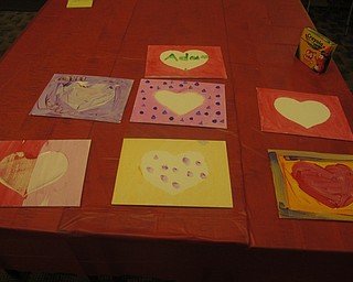 Neighbors | Zack Shively.The art station at the Austintown library's "I love STEAM" event allowed children to paint a canvas and peel a cover in the center of the canvas to reveal a white heart shape in the middle of the painting.