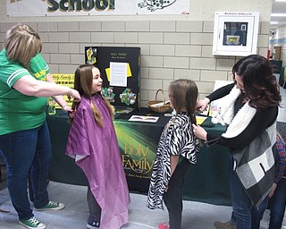 Neighbors | Zack Shively.Holy Family School celebrated Catholic Schools Week on the week of Jan. 29 to Feb. 2 and Student Appreciation Day on Feb. 2. Students participated in service projects throughout the week. Pictured, Rosalie Crawford cut Giuliana Ricchiuti's hair and Carmelina Iamurri cut Audrina Jablonski's hair for donation.