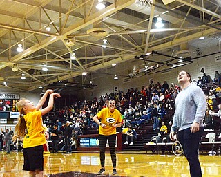 Scott Williams - The Vindicator - Payton Konnerth, age 9, from Robinwood Elementary School in Boardman, shoots a basket during halftime at the Austintown Fitch vs Spartan game on Friday February 23, 2018.  Corey Linsley, an '09 Boardman gard and NFL player, watches as Jen Flores, a Physical Education Teacher at Robinwood, cheers her student on.