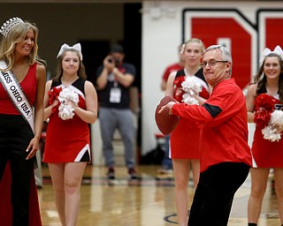 Miss Ohio USA Deneen Penn watches as Youngstown State President Jim Tressel attempts a half court shot with a football during the Burgan Real Estate, LTD. Mortgage Mania Challenge during the first half of a NCAA Horizon League college basketball game, Saturday, Feb. 24, 2018, in Youngstown...(Nikos Frazier | The Vindicator)
