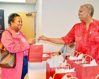 Delta Sigma Theta Alumnae and audit committe chair Lynette M. Sutton hands a gift bag to Cheryl McArthur who attended the Delta Sigma Theta Sorority Health Symposium at the Youngstown Metropolitan Housing Authority's Amedia Plaza on Saturday February 24, 2018.  Everyone who attended the event was handed a bag that contained an agenda, cup, candy, and pink ribbon bracelet.

Scott Williams - The Vindicator