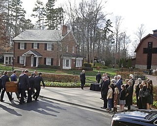 Pall bearers carry the casket carrying the body of Billy Graham past family member to the Billy Graham Library in Charlotte, N.C., Saturday, Feb. 24, 2018. Graham's body was brought to his hometown of Charlotte on Saturday, Feb. 24, as part of a procession expected to draw crowds of well-wishers. (AP Photo/Chuck Burton)