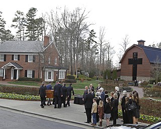 Pall bearers carry the casket carrying the body of Billy Graham past family member to the Billy Graham Library in Charlotte, N.C., Saturday, Feb. 24, 2018. Graham's body was brought to his hometown of Charlotte on Saturday, Feb. 24, as part of a procession expected to draw crowds of well-wishers. (AP Photo/Chuck Burton)