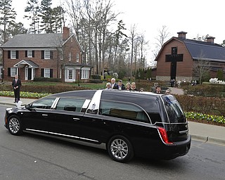 The hearse carrying the body of Billy Graham drives past family members as it arrives at the Billy Graham Library in Charlotte, N.C., Saturday, Feb. 24, 2018. Graham's body was brought to his hometown of Charlotte on Saturday, Feb. 24, as part of a procession expected to draw crowds of well-wishers. (AP Photo/Chuck Burton)