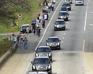 People watch as the hearse carrying the body of Billy Graham drives toward the Billy Graham Library in Cherryville, N.C., Saturday, Feb. 24, 2018. Graham's body was brought to his hometown of Charlotte on Saturday, Feb. 24, as part of a procession expected to draw crowds of well-wishers. (AP Photo/Kathy Kmonicek, Pool)